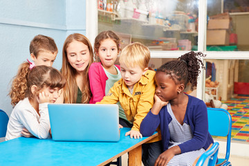 Kinder und Lehrerin zusammen am Laptop