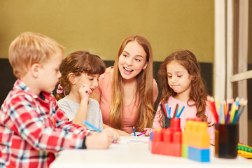 Kindergärtnerin und Kinder in einem Zeichenkurs