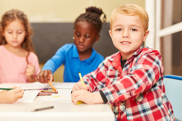 Fototapeta premium Junge als Schüler oder Vorschüler beim Malen