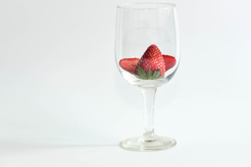 Strawberry in wine glass on white background