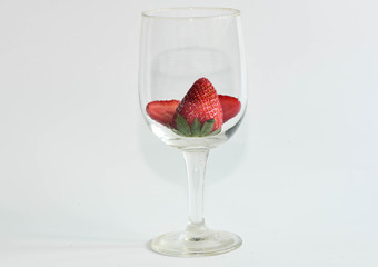 Strawberry in wine glass on white background