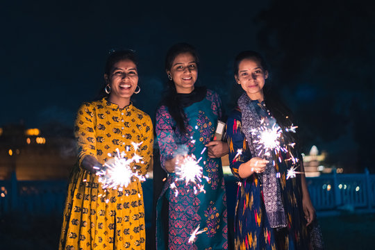 Three Young Indian Women With Bengal Fireworks, Celebrating Indian Festival Diwali. 