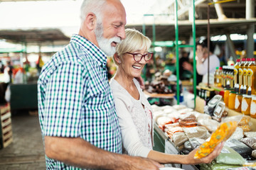 Fototapeta na wymiar Mature couple shopping vegetables and fruits on the market. Healthy diet.