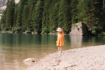 little girl on the shore of a beautiful lake