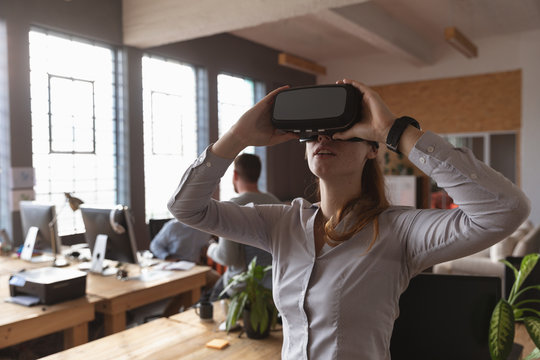 Young creative professional woman using VR headset in an office