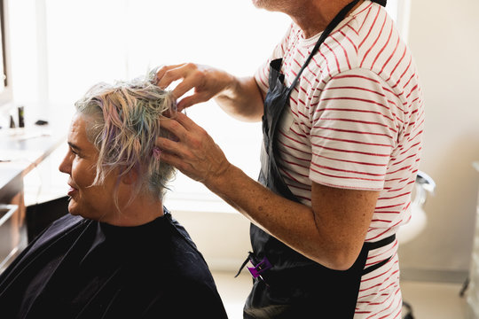 Male hairdresser and female client in hair salon
