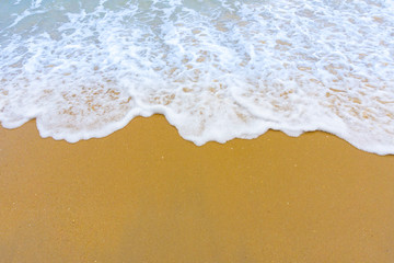 Fototapeta na wymiar Sea surf foam on the sand at the beach.