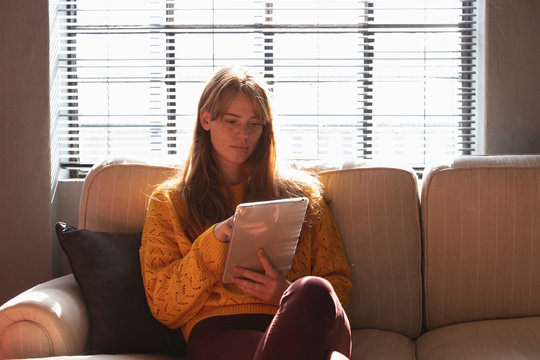 Young creative professional woman using tablet in a sunlit office