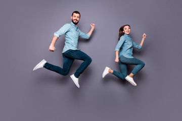 Fototapeta na wymiar Full size photo of cute married people run after sales discount wear denim jeans shirt isolated over grey background
