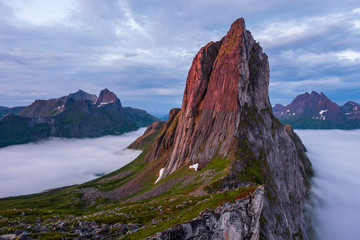 View on Iconic Mountain Segla in morninglight over a sea of mist and clouds, Fjordgard, Senja, Norway