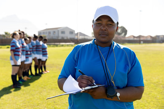 Female Rugby Coach And Team On A Rugby Pitch