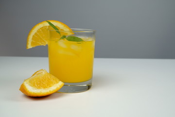 A glass of fresh orange juice on white table