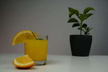 A glass of fresh orange juice on white table