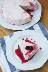 Cheesecake with sour cherries and sauce on a plate on wooden table. Sour cherry cheesecake on a plate