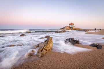 Sunrise at the beach with a church in the sea (Senhor da Pedra Chapel)