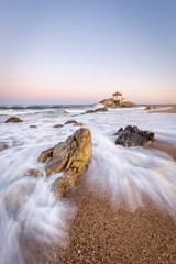 Sunrise at the beach with a church in the sea (Senhor da Pedra Chapel)