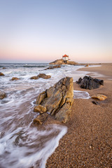 Sunrise at the beach with a church in the sea (Senhor da Pedra Chapel)