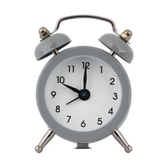 A gray clock with an alarm clock on a white background with arrows showing the time ten hours or twenty two hours