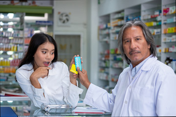 Selective focus of senior asian pharmacist man discussion how to use contraceptive pill and condom...
