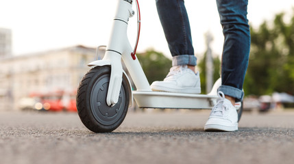 Crop guy on electric scooter on street