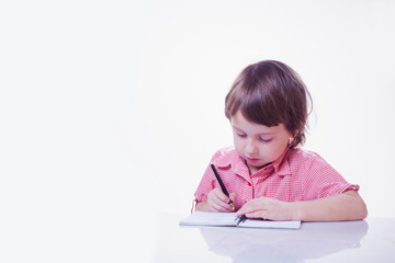 Cute little child girl writing his homework. Education and learning concept