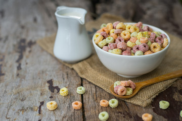 Milk and cornflakes in bowl on the wooden table