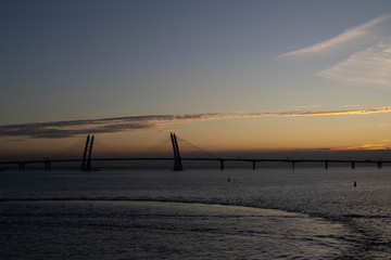 Long cable-stayed bridge on the background of a beautiful sunset on the sea