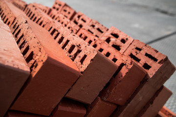 Pile of stacked new red bricks. Clay brick blocks ready for construction.