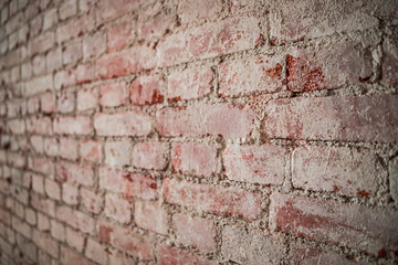 The wall of red dilapidated brick. The ruined brick wall close-up. Facade of a destroyed brick building. Pattern, texture, background.