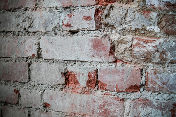 The wall of red dilapidated brick. The ruined brick wall close-up. Facade of a destroyed brick building. Pattern, texture, background.