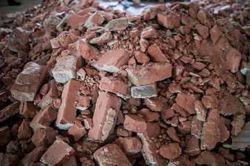 Broken brick and rubbish next to an old ruined building. Dump. Urban economy.
