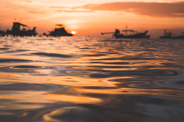 Amazing golden sunset at Koh Tao, Thailand, Asia. Beautiful light reflection on waves. Shallow depth of field. creative focus