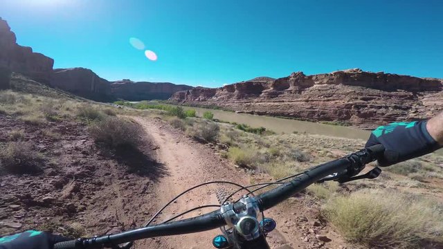 Cyclist Riding Mountain Bike Trail Beside A River