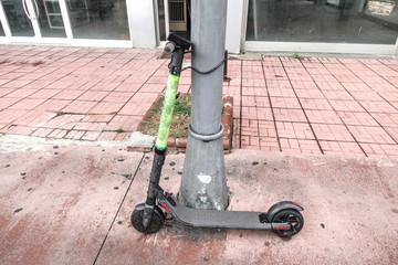 E-scooters of ride sharing company on the sidewalk. Electric kick scooters for rent - sharing.