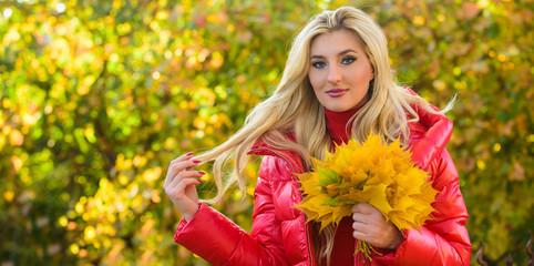 Girl blonde makeup dreamy face hold bunch fallen maple yellow leaves. Autumnal bouquet concept. Woman spend pleasant time in autumnal park. Lady posing with leaves autumnal nature background