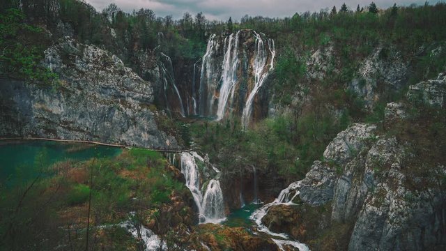 4k UHD Cinemagraph of fresh blue water flowing down beautiful waterfalls between a wooden foot bridge in the famous Plitvice National Park in Croatia, where the classic Winnetou movies were filmed.