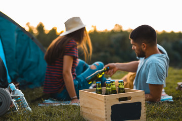 friends drinking beer on camping outdoor by the river