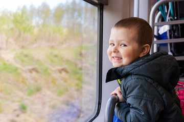 little boy looking through the bus window. Travelling with children.