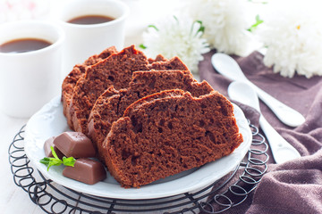 Sliced chocolate muffin on a white plate, selective focus
