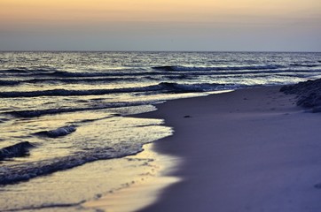 rising sun reflecting in the sea water on the beach