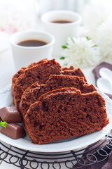 Sliced chocolate muffin on a white plate, selective focus