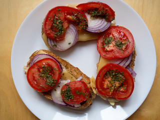 Fresh breakfast with yellow cheese, tomato, onion and parsley bread slices ready to eat