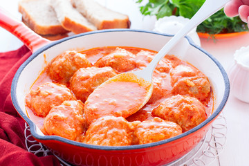 Chicken meatballs in a pan in tomato and sour cream sauce, horizontal
