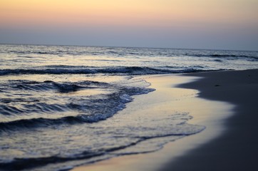 Fototapeta na wymiar rising sun reflecting in the sea water on the beach