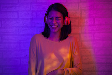 Fashion girl with red and blue light happy and relax with music from head phone 