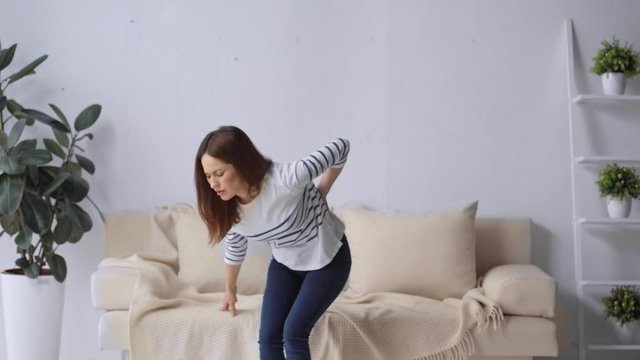 woman suffering from backache in living room