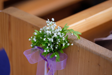 Festlicher Blumenschmuck an Kirchenbank
