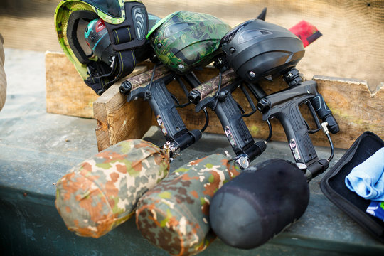 three paintball markers stand in a row
