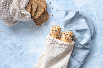two seeded chiabattas and slices of bread in a zero waste cotton bag on a beautiful, clean, rustic,...