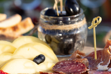 Cheese plates served with grapes, jam, figs, crackers and nuts on a wooden background,